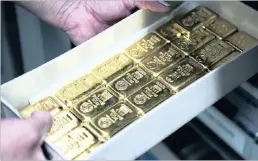  ??  ?? A bank employee places a storage tray containing gold bars. Ownership of raw materials by banks could be made very expensive by the US Fed.