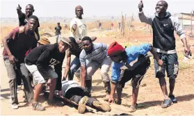  ?? Picture: Nigel Sibanda ?? CASUALTY. Unaville residents with an injured man.