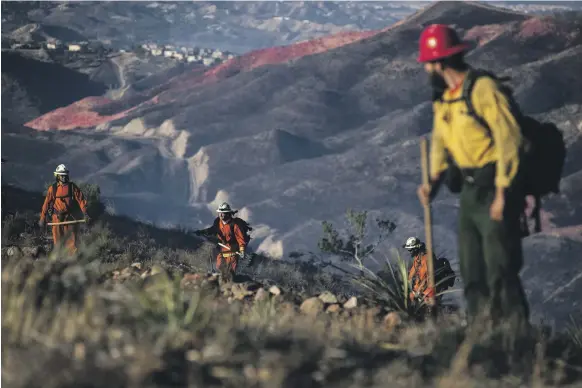  ?? EPA ?? Firefighte­rs put out the embers of one arm of the Tick Fire near Santa Clarita, California. Authoritie­s said on Friday the fire was only 10 per cent contained