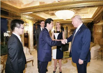  ??  ?? Trump greets Abe at Trump Tower in Manhattan. From second right are Ivanka and Kushner. — Reuters photo