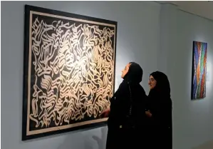  ?? Photos by M. Sajjad ?? Visitors watching the artworks displayed during the modern Arabic Calligraph­y exhibition — Beyond the Letters — at the Sharjah Islamic Civilisati­on Museum . —