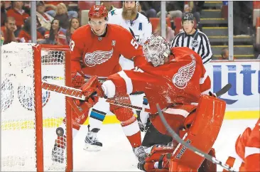  ?? Paul Sancya / The Associated Press ?? Detroit Red Wings goalie Jimmy Howard (right) reaches back to block a San Jose Sharks shot at the end of the second period.