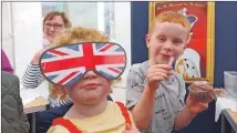  ?? ?? Five-year-old Johnathon Campbell, a P1 pupil at Clachan Primary School, and his little sister Haileigh, aged three, pinning the jewels on the crown at the village’s cream tea.