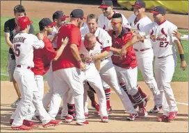  ?? J.B. FORBES/ASSOCIATED PRESS ?? Cardinals’ Brandon Moss, center, is mobbed by teammates after Moss singled in the winning run in the bottom of the ninth inning against the Colorado Rockies Sunday.