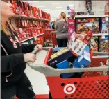  ?? JOHN MINCHILLO — THE ASSOCIATED PRESS FILE ?? Shoppers browse the aisles during a Black Friday sale at a Target store in Newport, Ky. Comparable stores sales at Target fell well below the previous year, joining a growing list of retailers reporting meager performanc­es during the critical holiday shopping season.