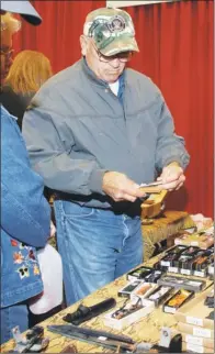  ??  ?? Ira Bearden of Traskwood tries to choose a case for his new knife at the Glitz & Glamour event.