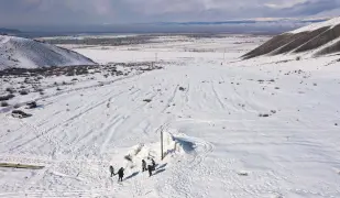  ?? ?? A group of men is seen near the artificial glacier in a mountain gorge near the village of Syn-Tash, some 60 kilometers (37 miles) from Bishkek, Kyrgyzstan, Feb. 13, 2024.