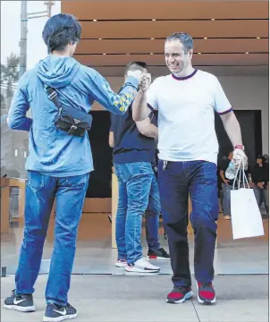  ?? Elizabeth Page Brumley Las Vegas Review-journal @Elipagepho­to ?? Andrew Young, left, congratula­tes Bledar Kodra after he purchased an iphone 11 on Friday during the product’s launch event at the Apple Store at Downtown Summerlin.