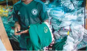  ?? — AFP ?? A man selling Nigerian World Cup jerseys is pictured in Balogun Market in Lagos on Thursday. The Nigeria Super Eagles jersey for the 2018 World Cup in Russia has been hugely popular.