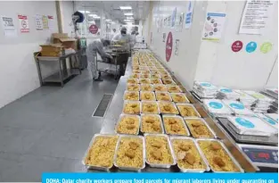  ??  ?? DOHA: Qatar charity workers prepare food parcels for migrant laborers living under quarantine on April 16, 2020 amid the coronaviru­s COVID-19 pandemic. —AFP