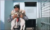  ?? NAVESH CHITRAKAR / REUTERS ?? A soldier kisses a puppy after offering prayers during the dog festival as part of Tihar in Kathmandu, Nepal, on Tuesday. Tihar is also known as Diwali.