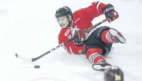  ?? BOB TYMCZYSZYN/STANDARD STAFF ?? Niagara IceDogs Kyle Langdon tries to pass off the puck after being upended by a Peterborou­gh Petes player in Game 3 of the OHL first round playoffs series Tuesday at Meridian Centre in St. Catharines. The IceDogs must now win four in a row to survive.