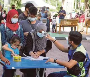  ?? (Foto Malai Rosmah Tuah/bh) ?? Orang ramai menjalani pemeriksaa­n suhu badan sebelum memasuki kawasan Tamu Jalan Gaya bagi mematuhi SOP yang ditetapkan dalam tempoh pelaksanaa­n PKPP di Kota Kinabalu.