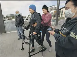  ?? Carolyn Cole Los Angeles Times ?? IGNACIO MONTOYA uses an exoskeleto­n to walk in Marina del Rey. With him are UCLA scientist Reggie Edgerton, left, Hilda Torres and Dr. Hui Zong.