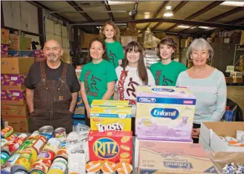  ?? FILE PHOTO ?? Claude Ruiz, from left, Meagin Warren, and Warren’s daughter, Cadence, back, Amy Acton, Jessica Crabtree and Karen Ruiz stand in the Choctaw Food Bank, one of the recipients of proceeds from the Clinton Hunger Run. The fifth-annual 5K run/walk is set...