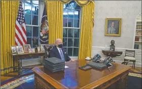  ?? (File Photo/AP/Evan Vucci) ?? President Joe Biden pauses as he signs his first executive orders in the Oval Office of the White House in Washington. On Friday, The Associated Press reported on a manipulate­d photo circulatin­g online incorrectl­y asserting it shows Biden asleep in his seat with a stack of executive orders in front of him.