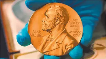  ?? AP FILE PHOTO ?? A Colombian national library employee shows the gold Nobel Prize medal awarded to the late novelist Gabriel Garcia Marquez in Bogota, Colombia. For the first time since 1943, there is a risk no Nobel Prize in literature will be awarded this year.