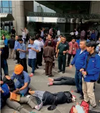  ?? AP ?? An Indonesian worker attends one of evacuated victims after a structure of the stock exchange tower collapsed on Monday. —