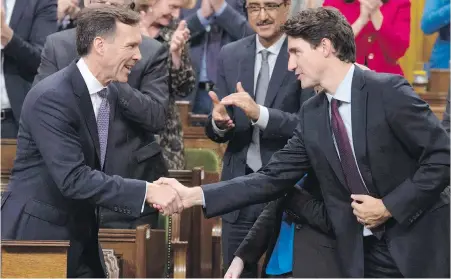  ??  ?? Finance Minister Bill Morneau shakes hands with Prime Minister Justin Trudeau after delivering his fall economic statement.