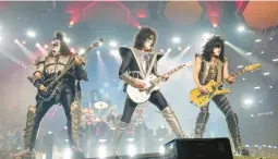  ?? EVAN AGOSTINI/INVISION ?? Gene Simmons, from left, Tommy Thayer and Paul Stanley of Kiss perform Dec. 2 in New York. The rock band has sold its catalog, brand name and IP.