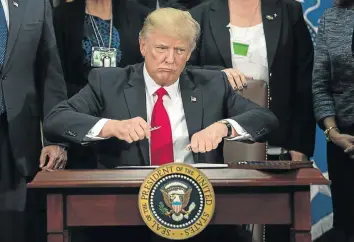  ?? Picture: AFP ?? FROM TV TO REALITY: US President Donald Trump takes the cap off a pen to sign an executive order to start the Mexico border wall project at the Department of Homeland Security facility in Washington, DC