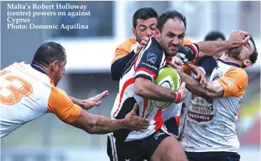  ??  ?? Malta’s Robert Holloway (centre) powers on against Cyprus Photo: Domenic Aquilina