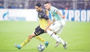  ?? — Gambar Reuters ?? TEWAS: Hakimi (kiri) mengawal bola ketika cuba dirampas oleh pemain Inter pada perlawanan Liga Juara-Juara di Stadium Signal Iduna Park, Jerman kelmarin.