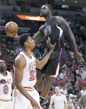  ?? Lynne Sladky/Associated Press ?? Clippers forward Lance Stephenson, right, goes to the basket as Heat center Hassan Whiteside defends in a game Sunday in Miami.