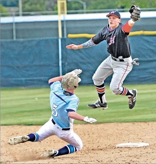  ?? Dan Watson/The Signal ?? In this file photo, Saugus’ Adam Sinatra (5) slides under a wild throw to Hart’s Nick Valaika. Valaika was drafted in the 24th round Wednesday.