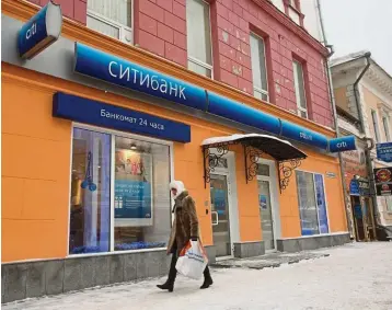  ?? — Bloomberg ?? Rising transactio­ns: A file picture showing a woman passing a Citibank branch in Nizhny Novgorod, Russia. The bank’s digital wealth management transactio­ns rose 37% in the first two months of the year in Hong Kong.