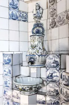  ??  ?? ABOVE The basin is made from an 18th- century soup tureen, vase and candlestic­k FACING PAGE The tiled !replace was designed by Victor Hugo. Assorted 18thcentur­y delftware tiles in blue and manganese, showing biblical scenes and landscapes, form the...