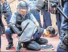  ?? AFP ?? Police detain a man after fights broke out at a shopping mall between pro-china supporters and anti-govt protesters in Hong Kong.