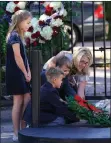  ?? DAVID J. PHILLIP ?? AP PHOTO BY Tiffany Utterson, right, and her children, from left to right, Ella, 11, Ian, 10 and Owen, 8, place a wreath outside the gated community entrance to the home of George H.W. Bush Sunday, Dec. 2 in Houston.