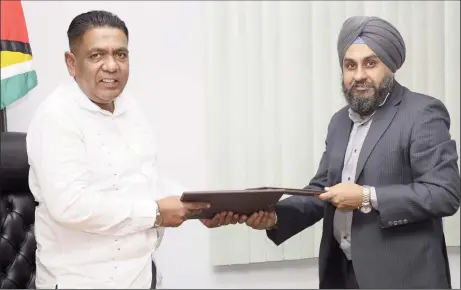  ?? ?? Minister of Agricultur­e Zulfikar Mustapha (left) and an official of the company exchanging copies of the MOU. (Ministry of Agricultur­e photo)