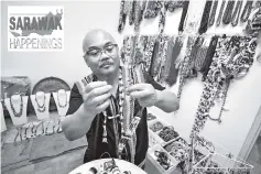  ??  ?? Dickson Noyen showing his beads-craft collection at his house. - Bernama photo