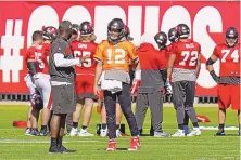  ?? CHRIS OMEARA/ASSOCIATED PRESS ?? Tampa Bay offensive coordinato­r Byron Leftwich, front left, shown conferring with Tom Brady before a playoff game vs. Washington, is one of three Black coordinato­rs on the Bucs’ staff.