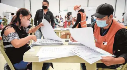  ?? AFP ?? Miembros del Consejo Nacional Electoral durante el recuento de votos en Quito