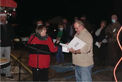  ??  ?? On Monday, Norphlet city council member Diane Marks, left, presented Mayor Jim Crotty with a plaque honoring him as the town’s 2020 Citizen of the Year. (Matt Hutcheson/News-Times)