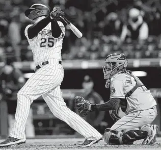  ?? Matthew Stockman / Getty Images ?? Catcher Martin Maldonano, watching the Rockies’ C.J. Cron stroke a two-RBI double in the sixth inning on Tuesday at Coors Field, was one of four Astros players to rejoin the team.