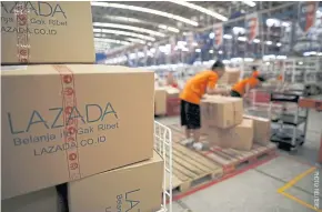  ??  ?? Employees at the online retailer Lazada fill orders at the company’s warehouse in Jakarta.