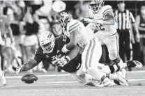  ?? Sue Ogrocki / Associated Press ?? Linebacker Deontay Anderson, center, and his UH teammates have been adept at forcing turnovers this season.