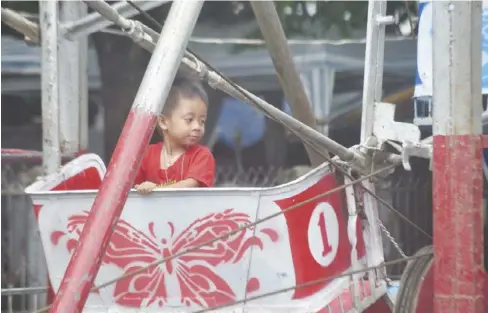  ?? JOSELITO VILLASIS/PN ?? ALONE BUT HAPPY. Many people should take inspiratio­n from this boy, who feels comfortabl­e sitting alone in a Ferris wheel car at the public plaza in Molo, Iloilo City where there is a fair on Tuesday, June 27.