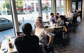  ?? Photos by Lance Iversen / The Chronicle ?? Stefan Cassara and Katra Cassara of Berkeley enjoy Le Cheval restaurant in Oakland, which reopened in the place it had occupied until 2009.