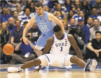  ?? Robert Willett / Raleigh News & Observer ?? Duke’s Zion Williamson falls to the court Wednesday night in front of North Carolina’s Luke Maye. The Duke star’s knee was sprained, leading some to say he should quit the Duke team.