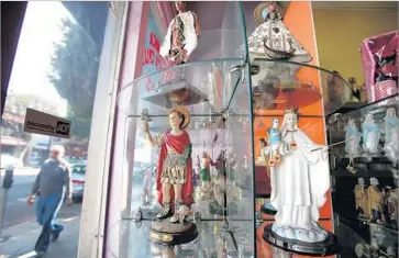  ?? Luis Sinco Los Angeles Times ?? RELIGIOUS ICONS line the shelves of a Boyle Heights shop. The neighborho­od, east of downtown, was once a Jewish community. Today, it’s made up largely of Mexican Americans and Central American immigrants.