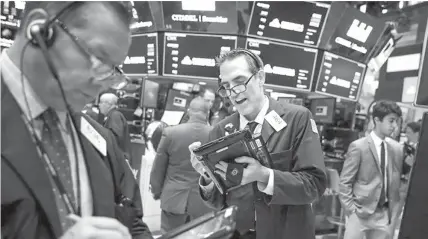  ?? AGENCE FRANCE PRESSE ?? Traders and financial profession­als work on the floor of the New York Stock Exchange (NYSE) at the opening bell in New York City.