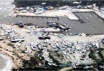  ??  ?? 220mph winds: Leisure boats scattered by the heavy seas on holiday islands