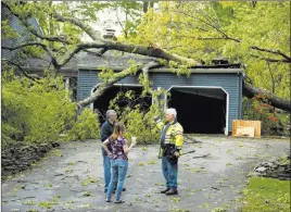  ?? Patrick Raycraft ?? The Associated Press Chris Fletcher, left, and his wife Noel survey the storm damage to their home in Cheshire, Conn., on Wednesday with a Cheshire volunteer firefighte­r.