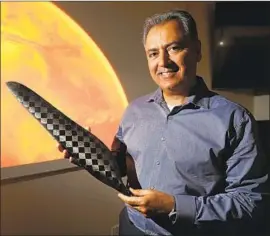  ?? Al Seib Los Angeles Times ?? WAHID NAWABI, AeroVironm­ent’s CEO, holds a rotor blade for the Mars Helicopter drone. Made of foam and carbon-fiber composites, it is light but strong.