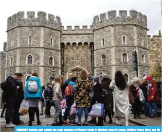  ?? — AFP ?? WINDSOR: Tourists wait outside the main entrance of Windsor Castle in Windsor, west of London. Britain’s Prince Harry and US actress Meghan Markle will marry on May 19 at St George’s Chapel in Windsor Castle.